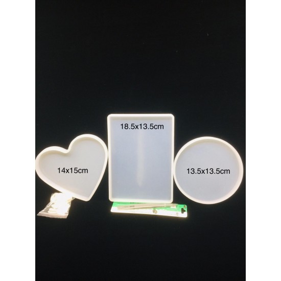 Three silicone heart molds and a round and rectangular coaster with tweezers and a finger cap lid